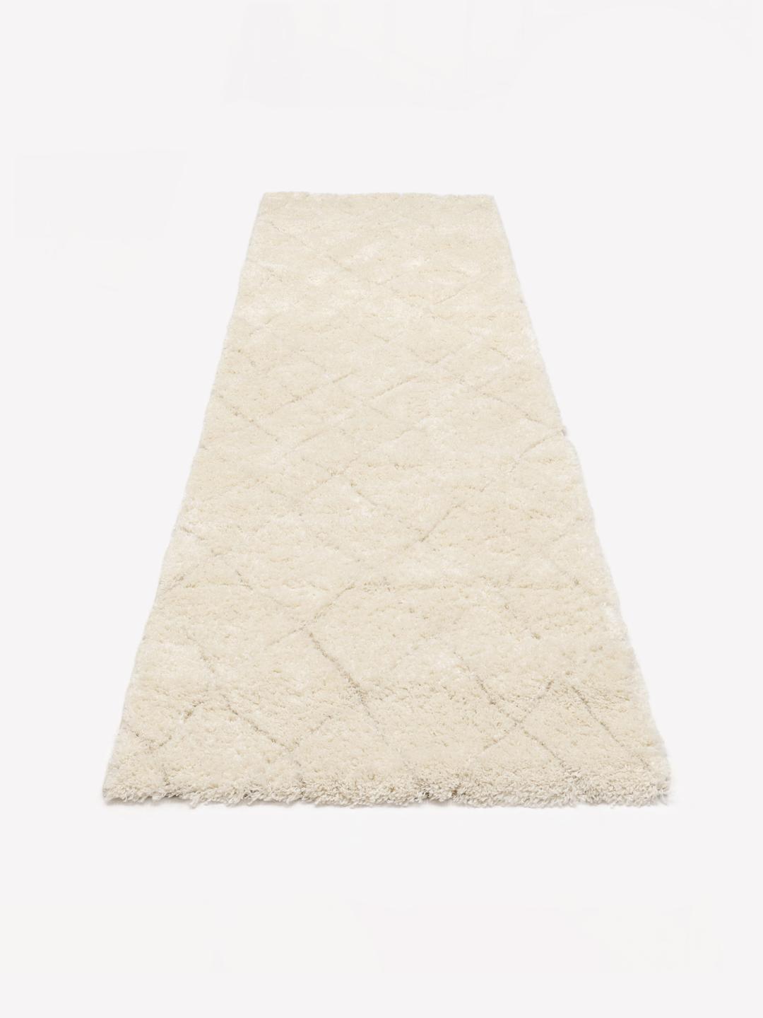 Witte loper met een zachte hoogpolige textuur en een subtiel ruitpatroon