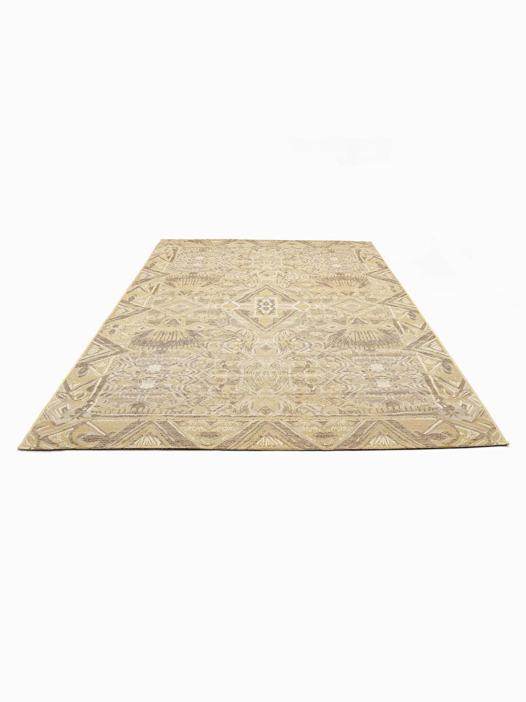 Een beige vloerkleed met een geometrisch tribaal patroon