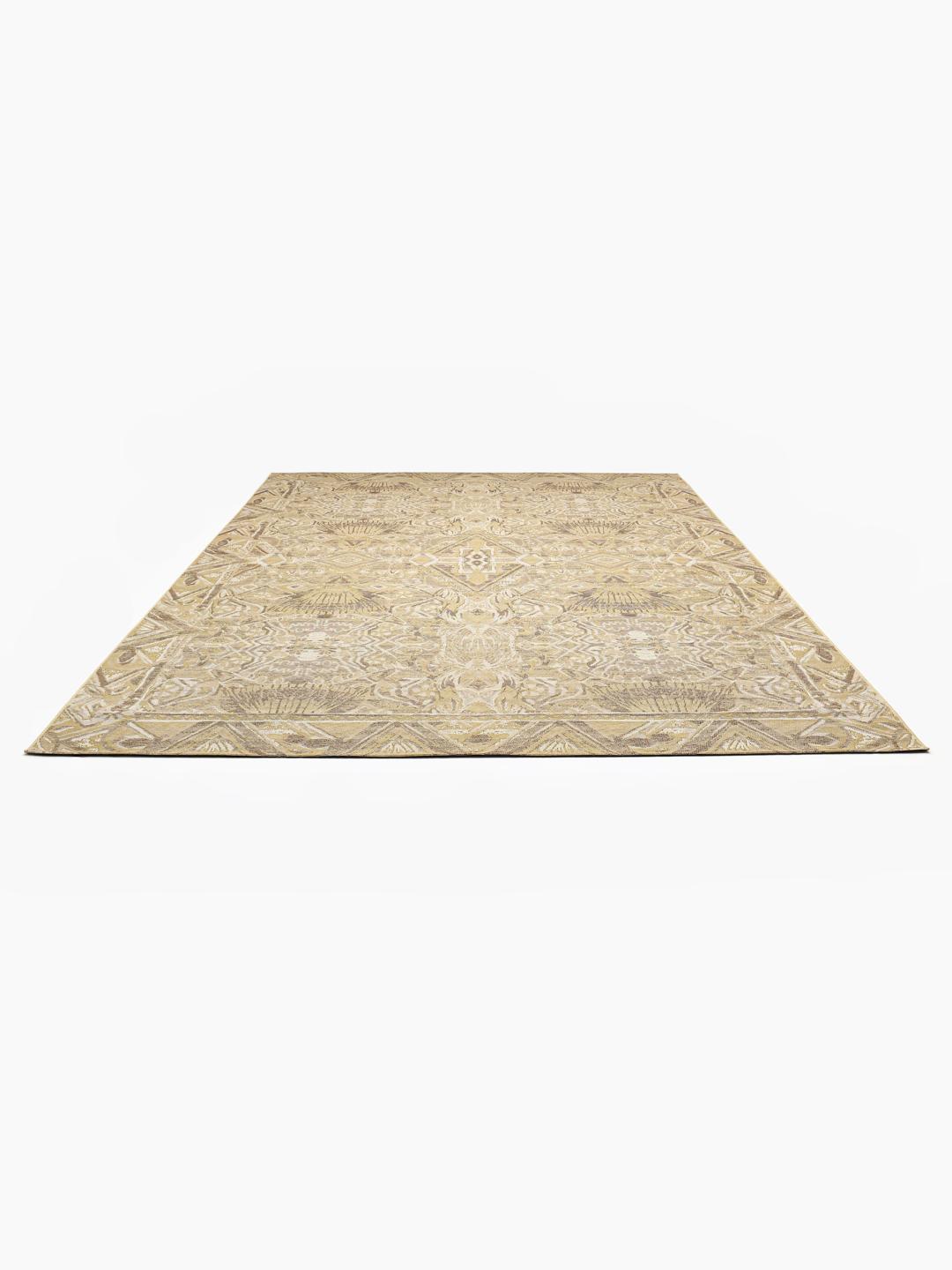 Een beige vloerkleed met een geometrisch tribaal patroon