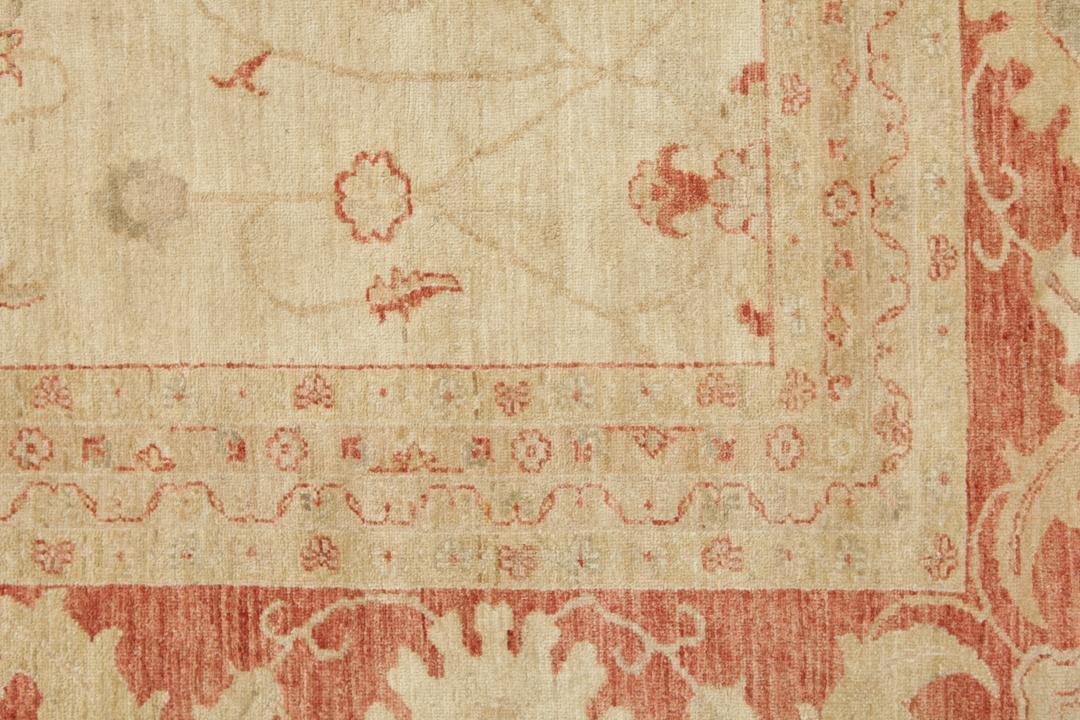 A large hand-knotted rug from Pakistan featuring a beige field and terracotta floral border.