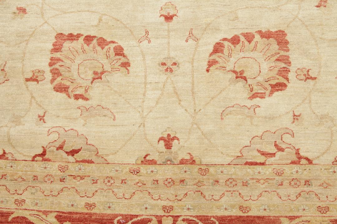 A large hand-knotted rug from Pakistan featuring a beige field and terracotta floral border.