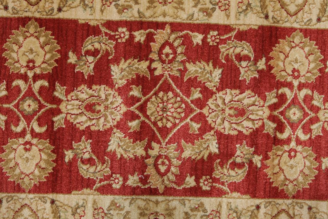 Rode loper met traditionele bloemmotieven en decoratieve randen