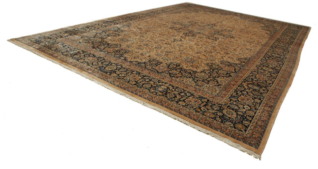 A large rectangular hand-knotted Mashad Astan Ghods rug with a beige field and floral motifs