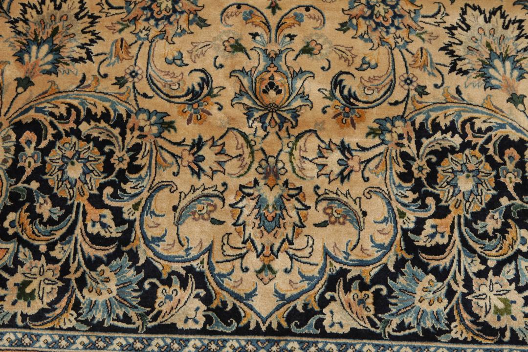 A large rectangular hand-knotted Mashad Astan Ghods rug with a beige field and floral motifs