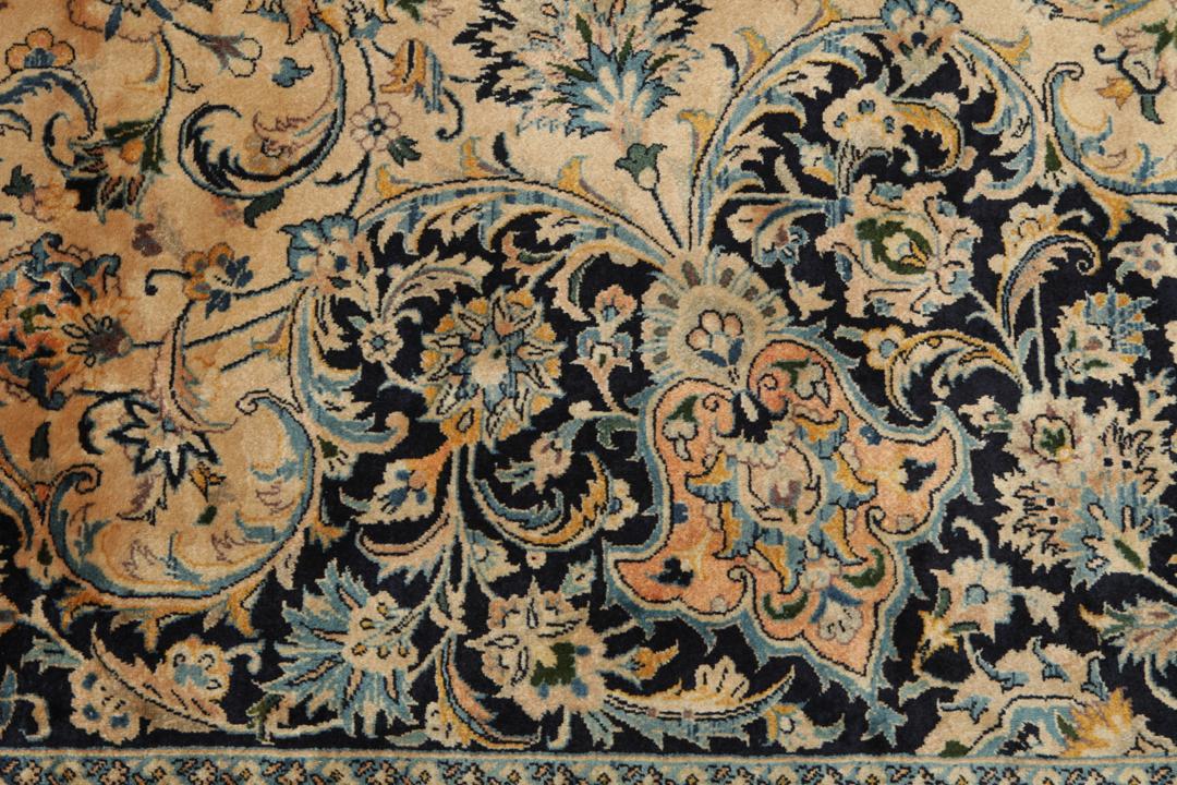 A large rectangular hand-knotted Mashad Astan Ghods rug with a beige field and floral motifs