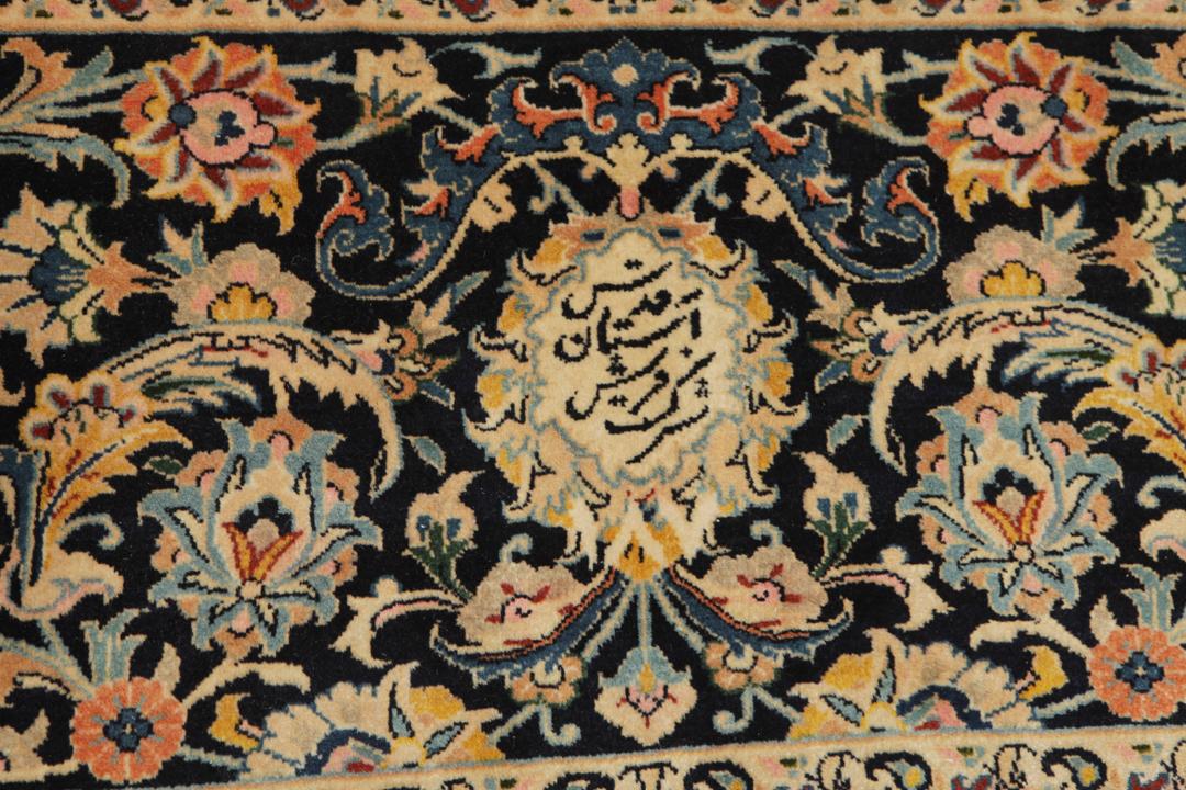 A large rectangular hand-knotted Mashad Astan Ghods rug with a beige field and floral motifs