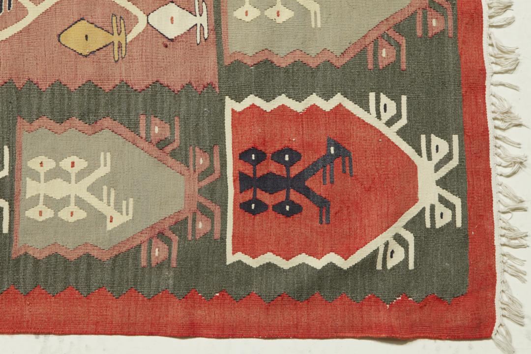 Een groot handgeweven semi-antiek Turks kelimkleed met geometrische motieven in multicolor.