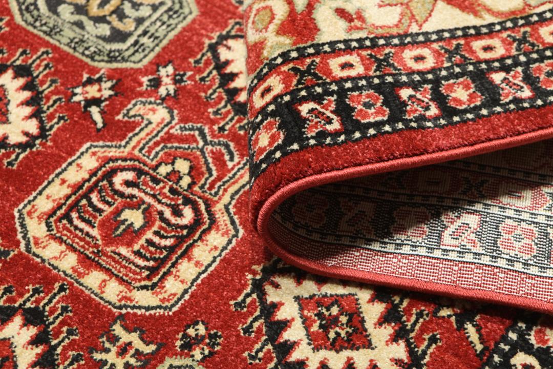 rødt tæppe med detaljerede motiver og fransser