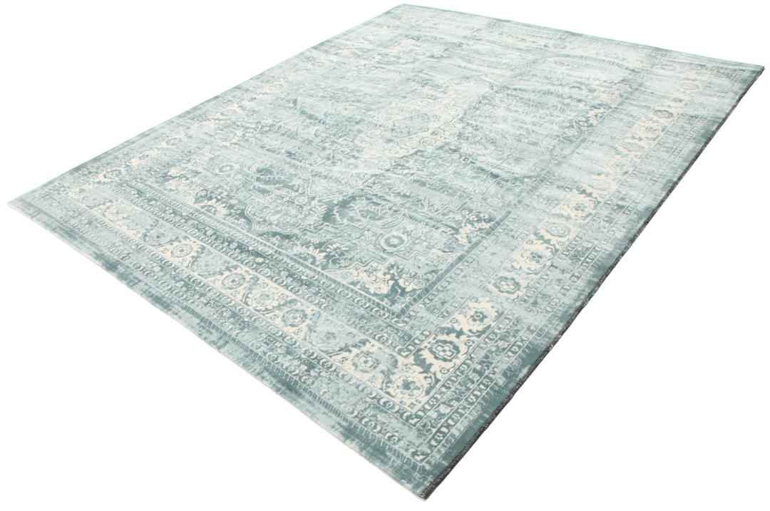 Light blue rug with a traditional patterned border and central medallion.