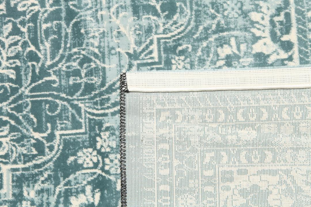 Light blue rug with a traditional patterned border and central medallion.