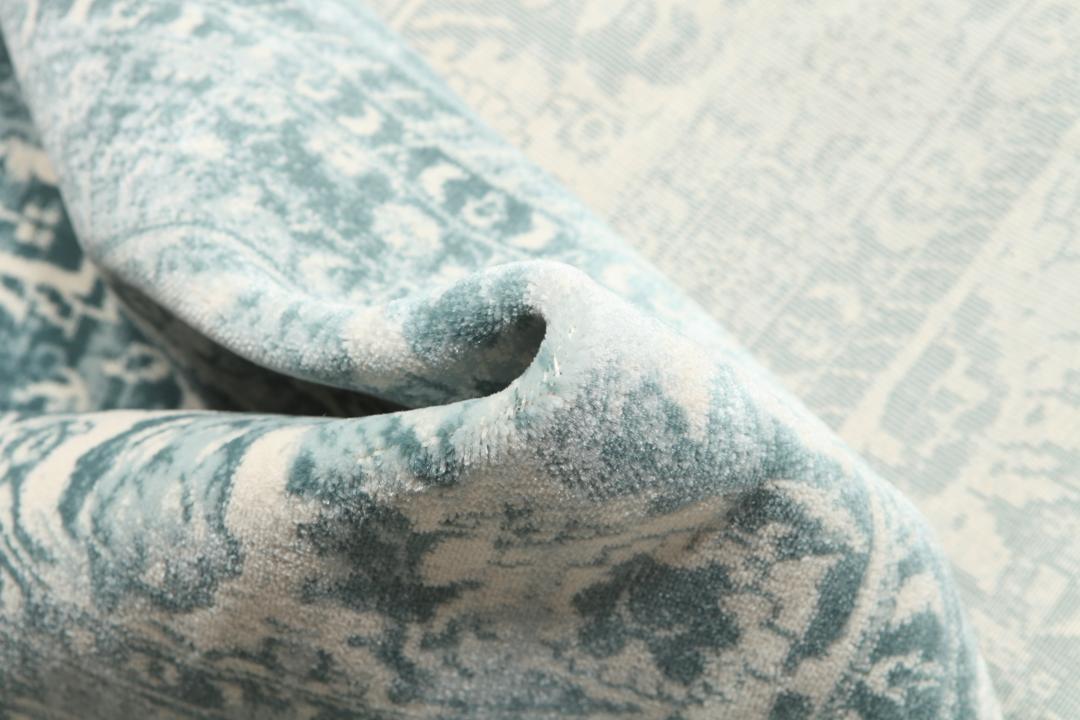 Light blue rug with a traditional patterned border and central medallion.