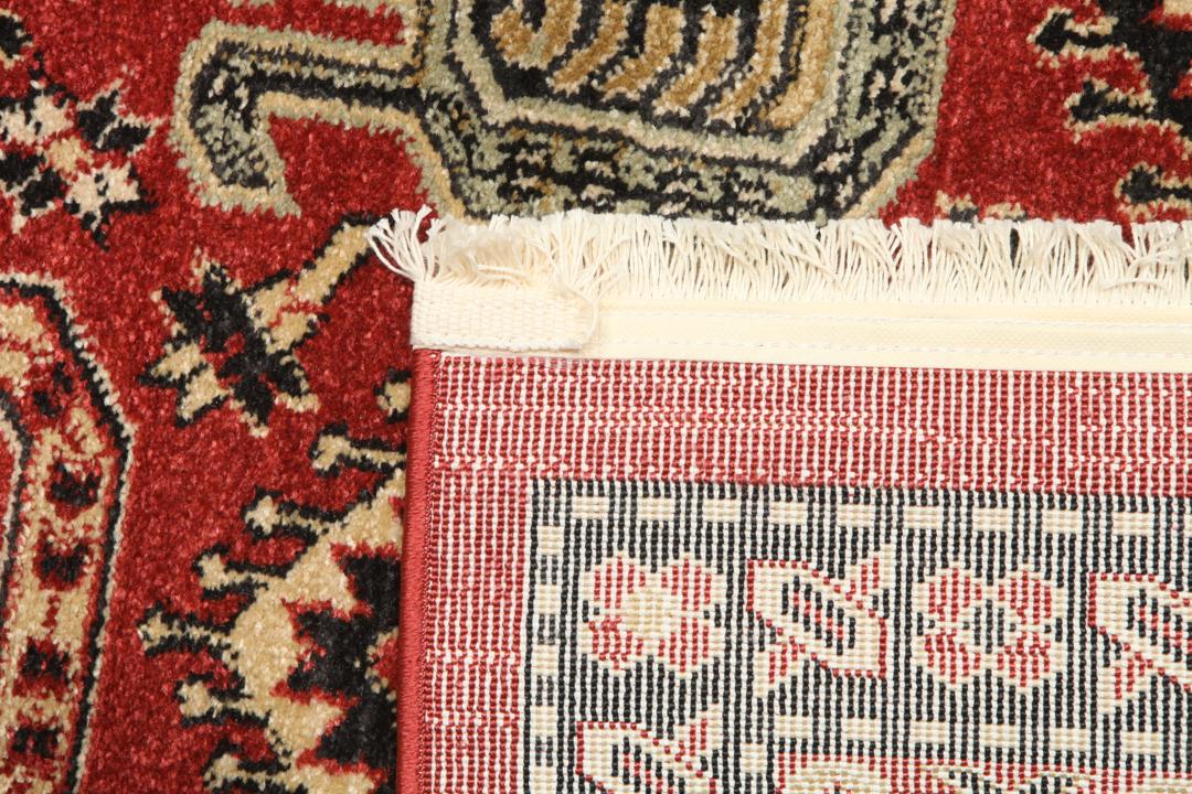 rood vloerkleed met gedetailleerde motieven en franjes