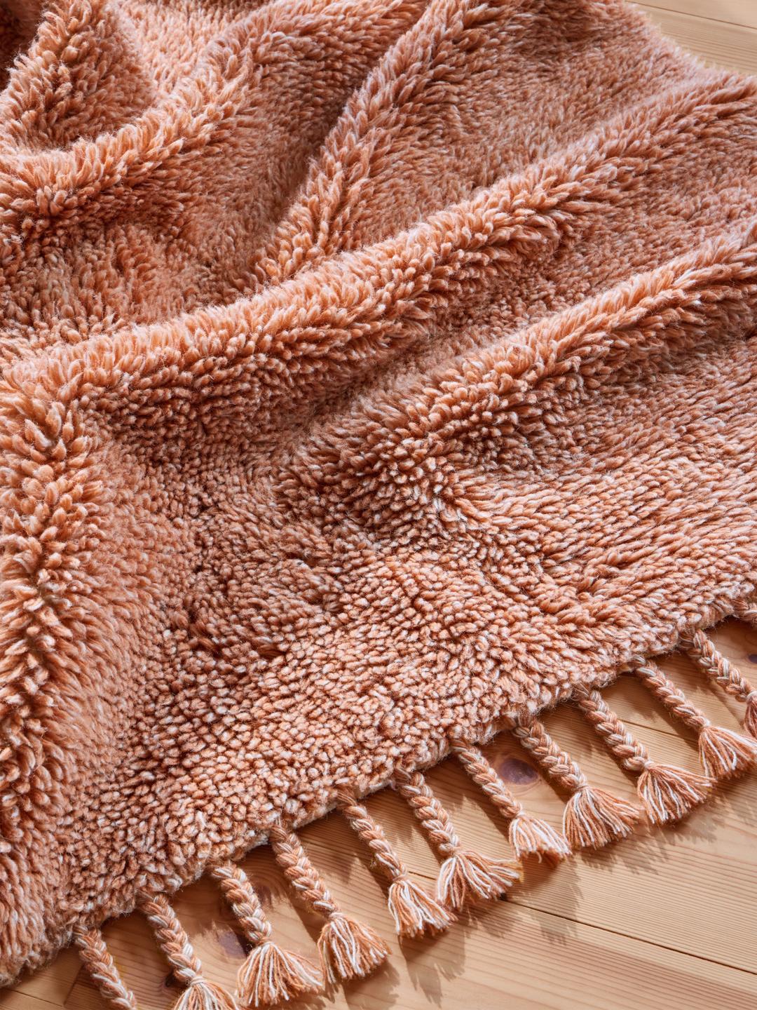 Een zacht terracotta shaggy kleed met franjes