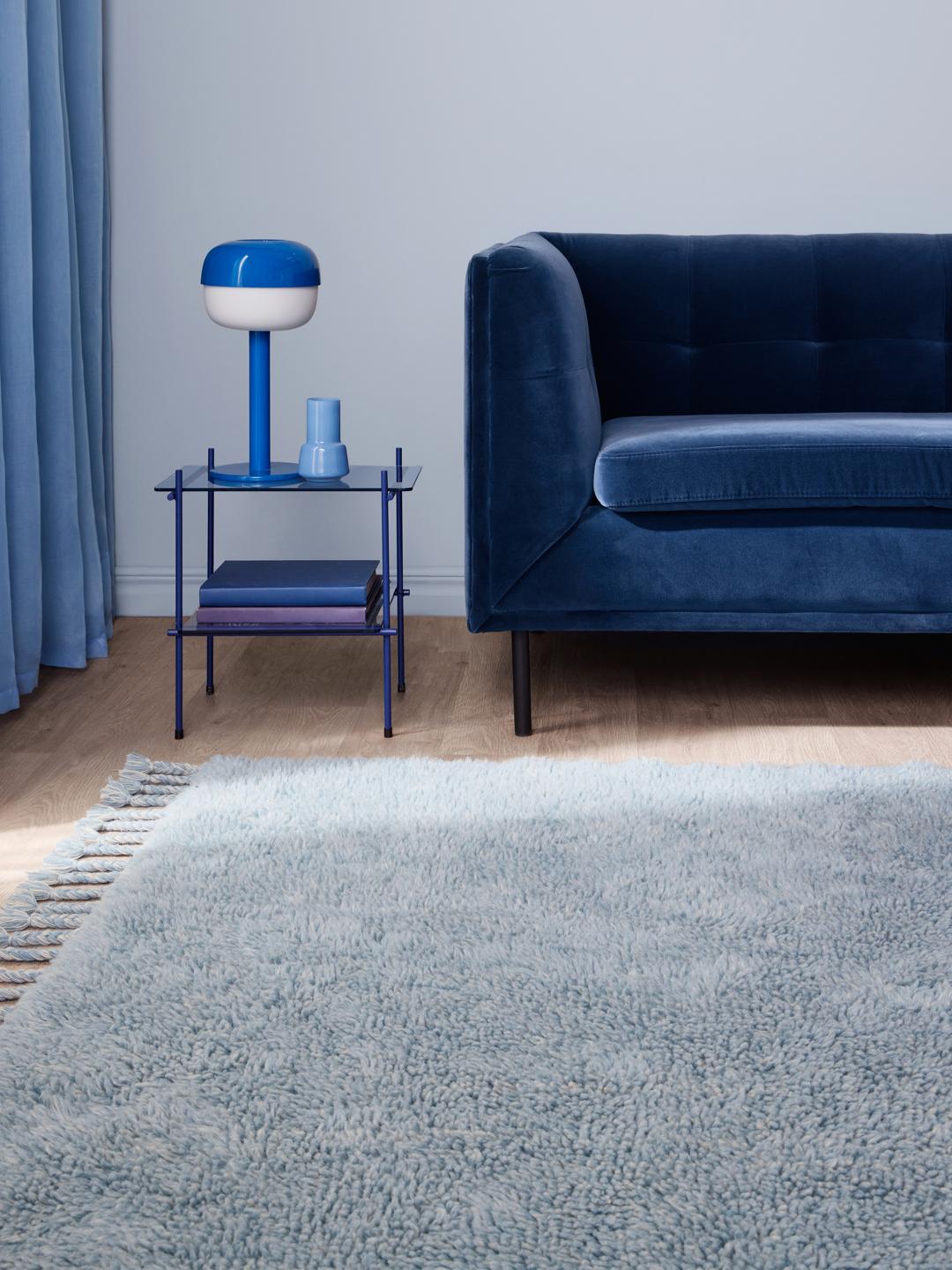 Een pluche blauw shaggy tapijt met franjes.