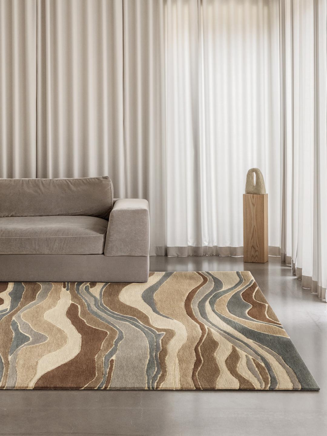 Handgetuft grijs en beige wollen vloerkleed met een organisch golfpatroon.