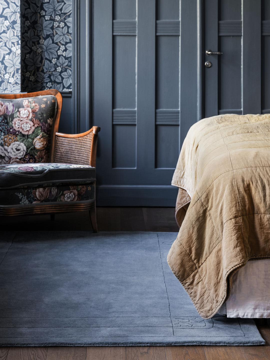 Een zacht blauw tapijt met een decoratieve rand.