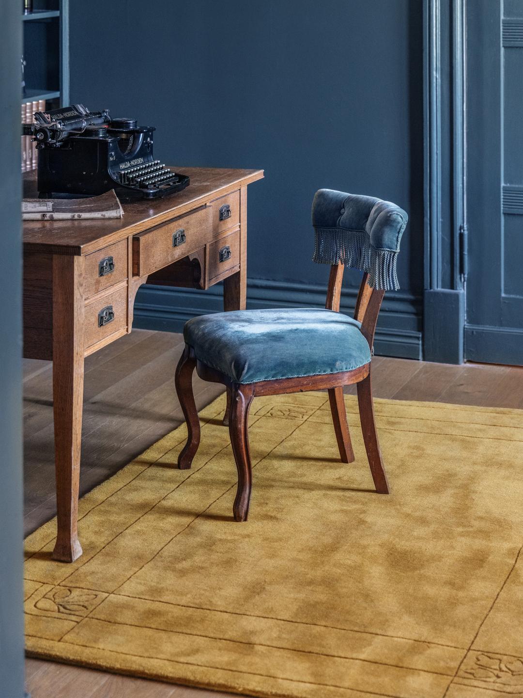 Goudkleurig vloerkleed met een decoratieve rand