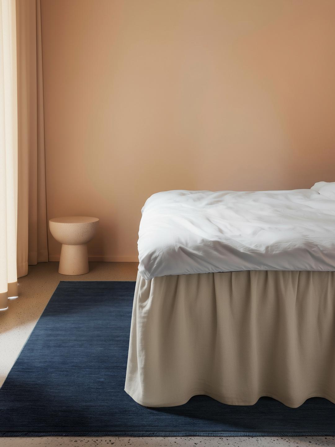 Een donkerblauw handgeweven vloerkleed met korte franjes langs de randen