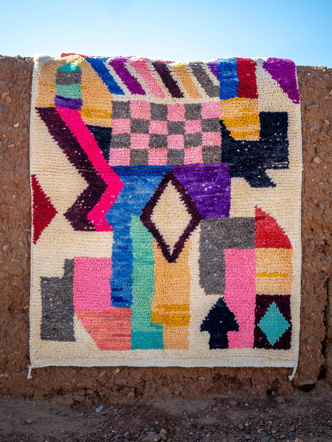 Un tapis berbère marocain vibrant, noué à la main, avec des formes géométriques et des couleurs multiples.