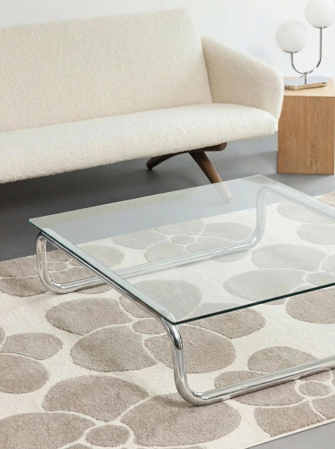 Un tapis floral beige et blanc cassé avec une texture de poil doux.