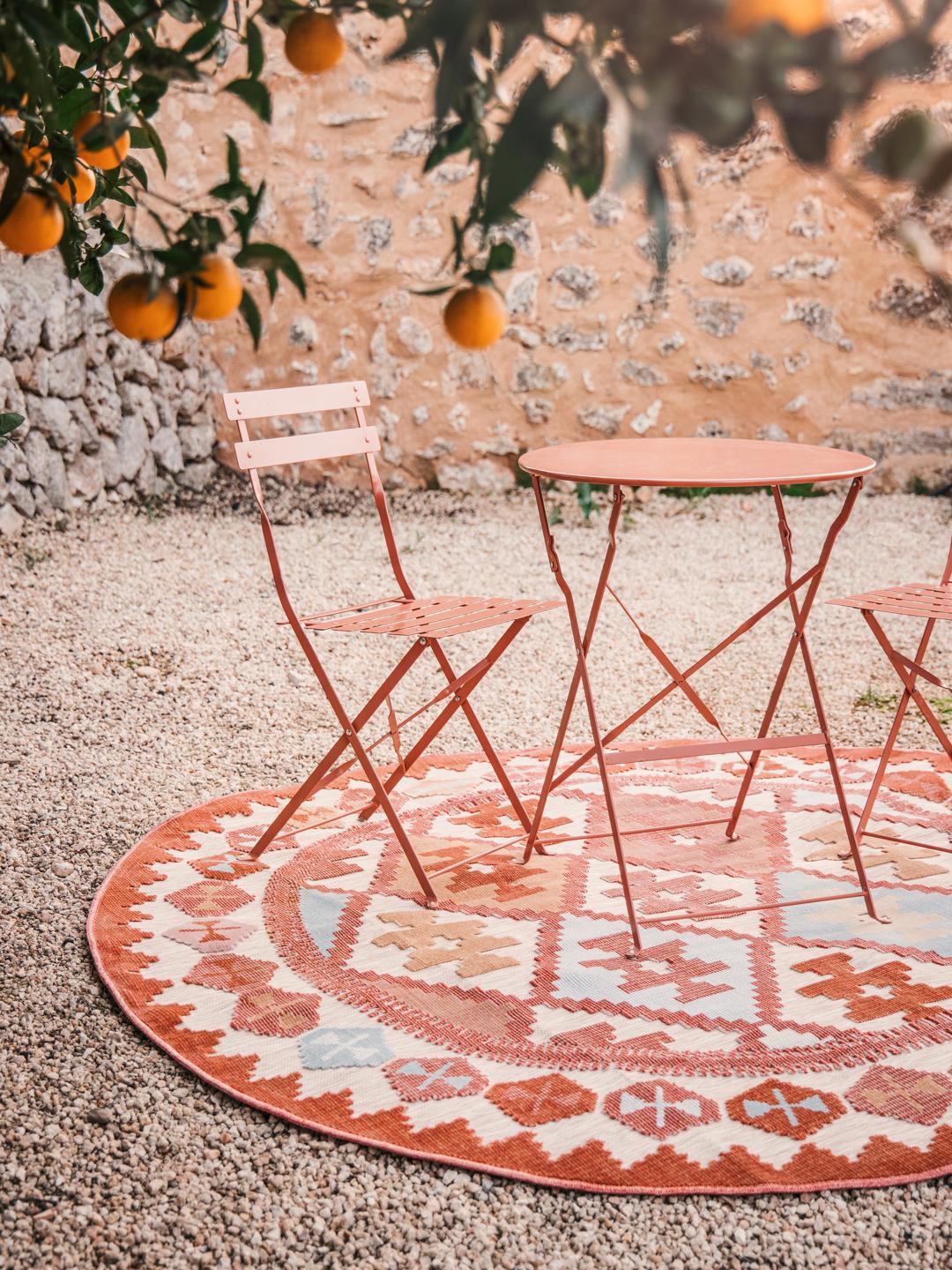 Rond vloerkleed met een beige en meerkleurig patroon geïnspireerd op kilims