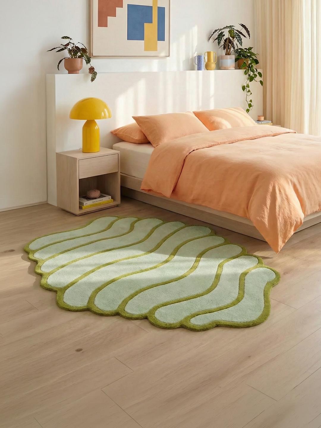 Vloerkleed in mintgroen met een onregelmatige vorm en zachte pool.