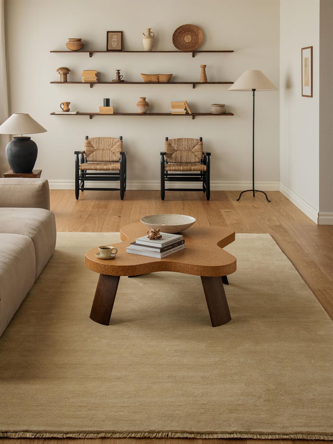 Een eenkleurig beige vloerkleed met verfijnde franjes