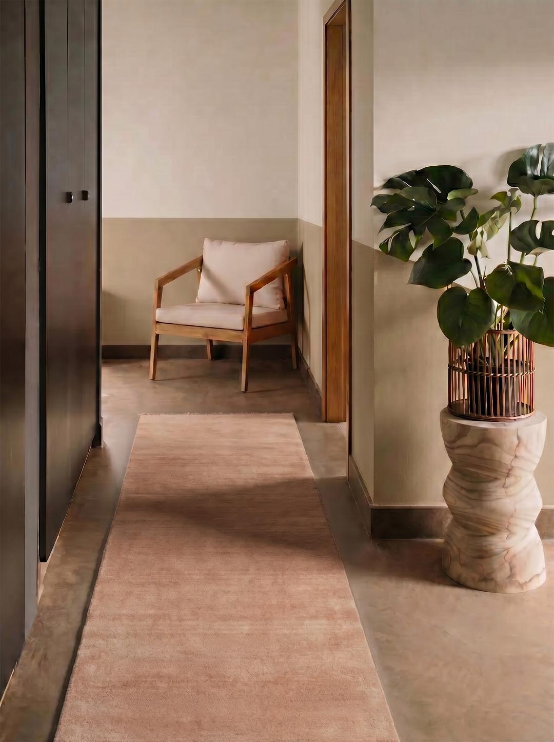 Un tapis de couloir rose uni avec des franges délicates aux extrémités.