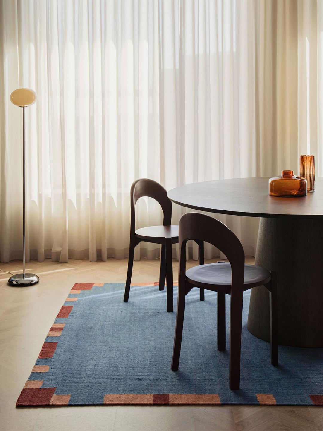 blauw en meerkleurig wollen tapijt met een geometrische rand