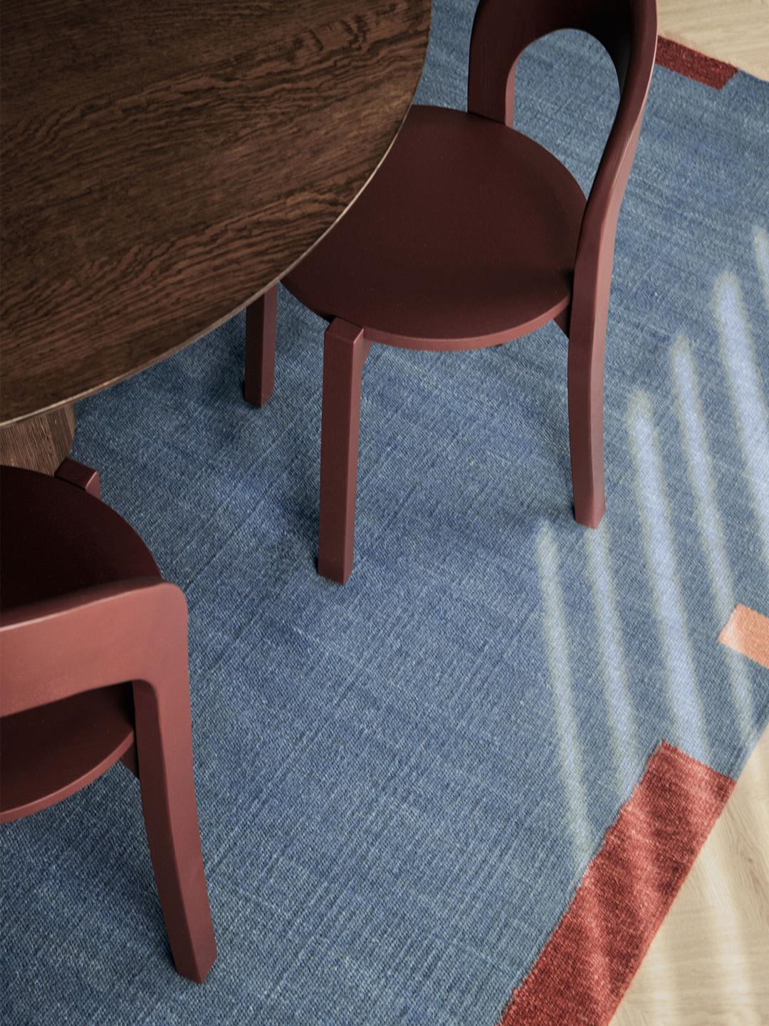 blauw en meerkleurig wollen tapijt met een geometrische rand