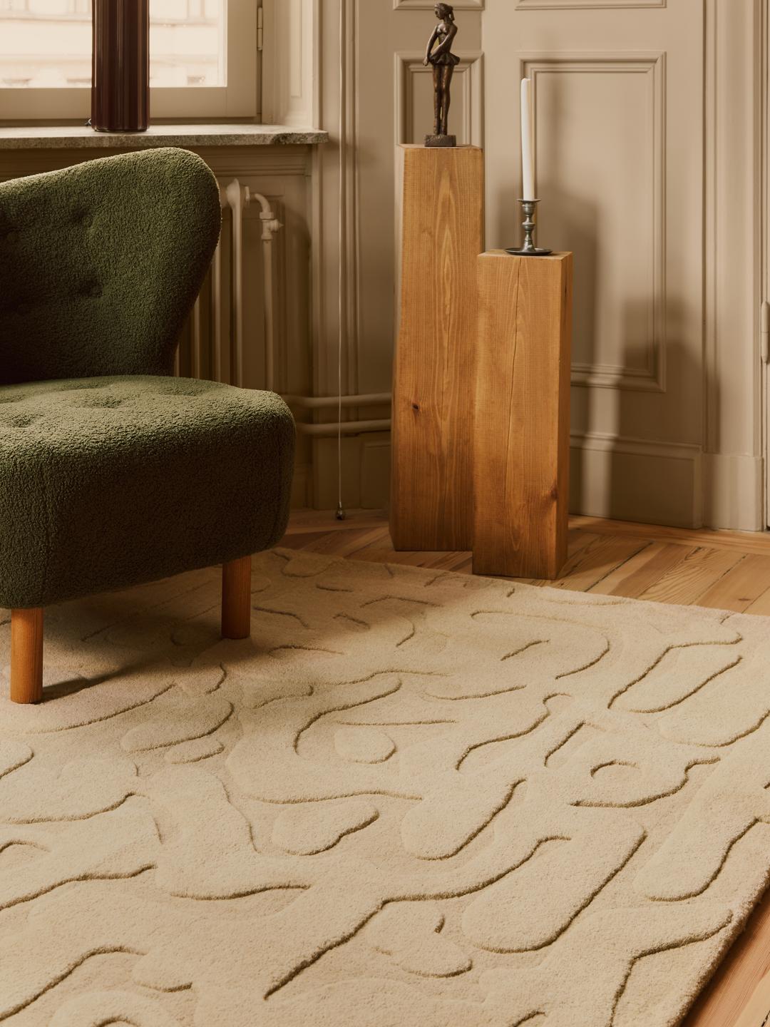 Een modern handgetuft beige vloerkleed met een abstract hoog-laag reliëfpatroon