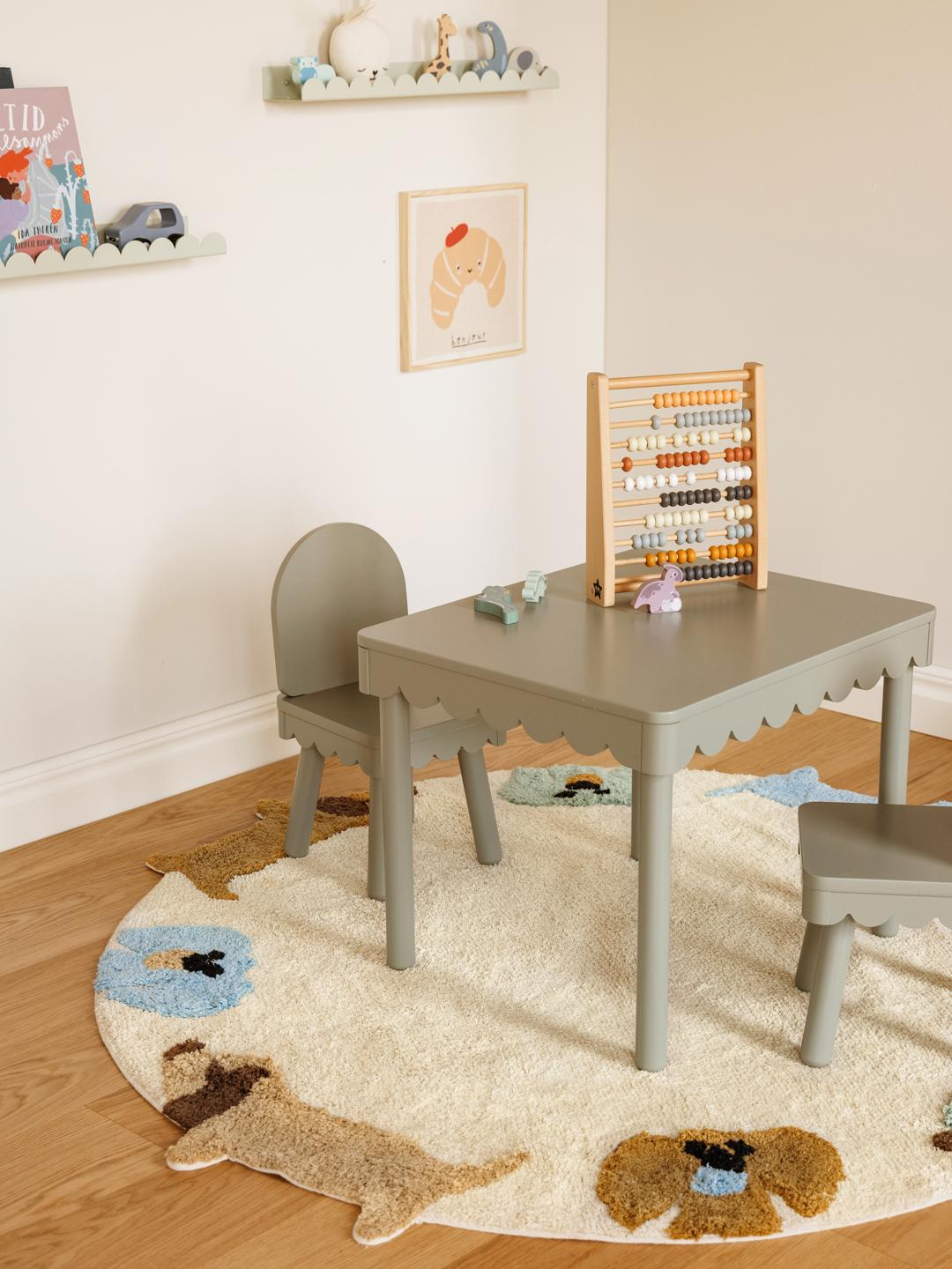 Een rond meerkleurig kinderkleed met een cirkel van pastel puppy's
