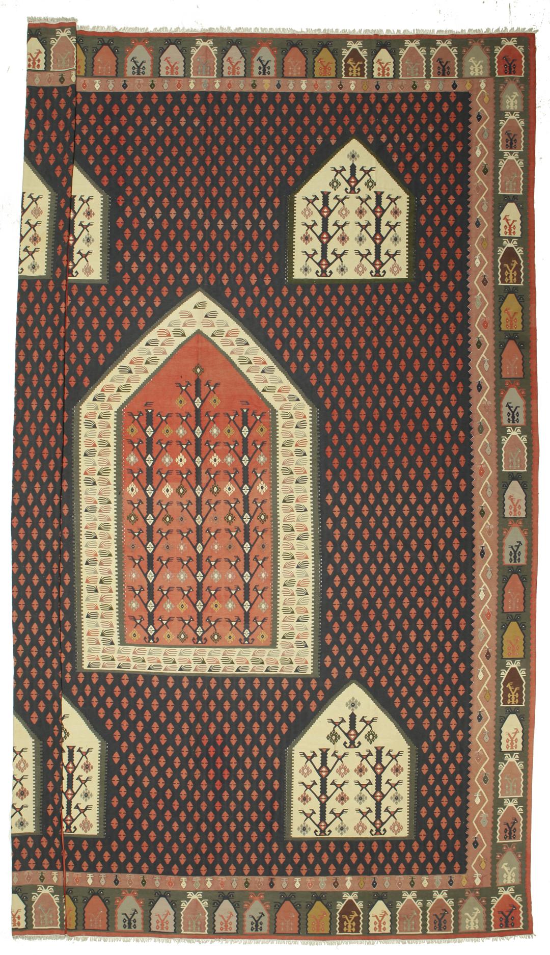 Een groot handgeweven semi-antiek Turks kelimkleed met geometrische motieven in multicolor.