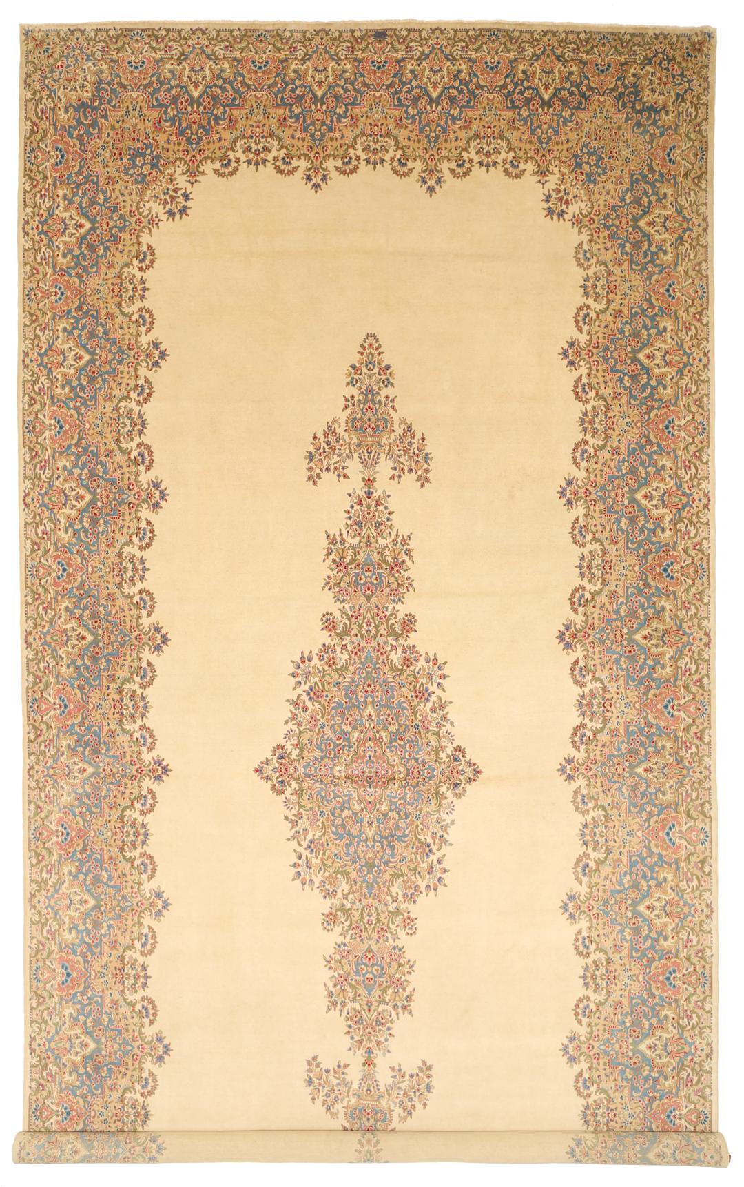 Large Kerman rug from the Middle East featuring a central floral medallion in beige, blue, and pink tones.