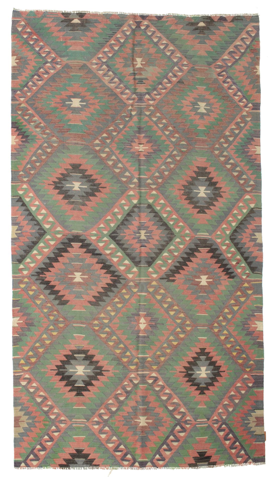 Een vintage Turks Kelim-tapijt met een geometrisch patroon in groene, bruine en rode tinten.