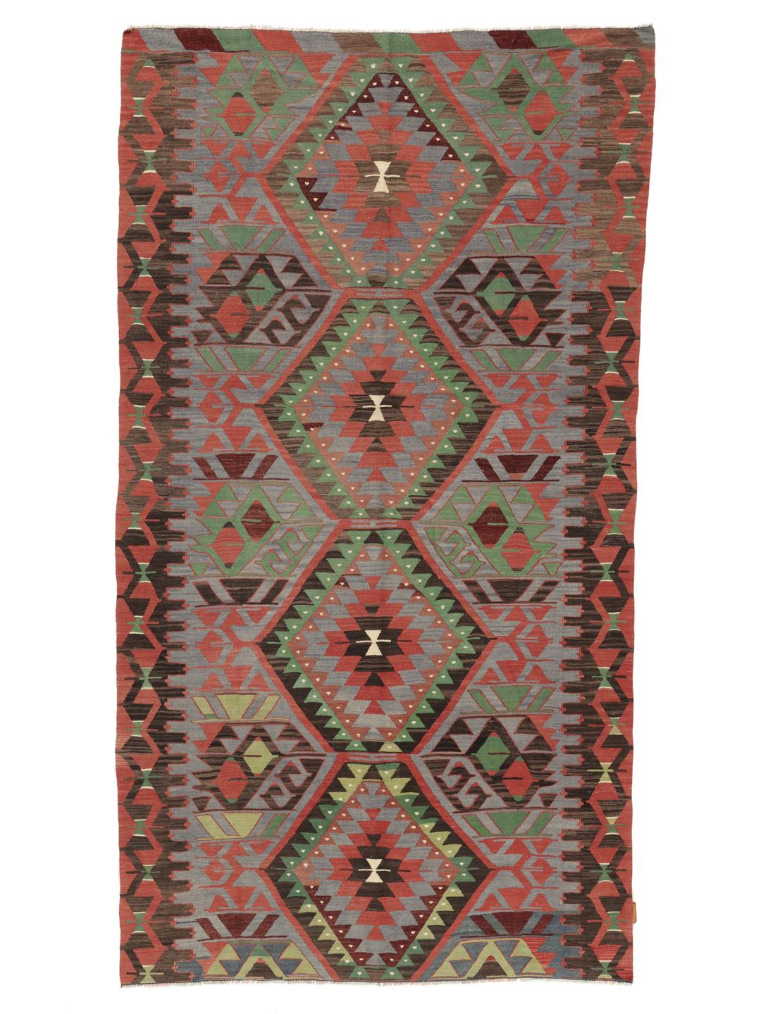 Un tapis Kelim turc vintage présentant un motif géométrique en laine multicolore.