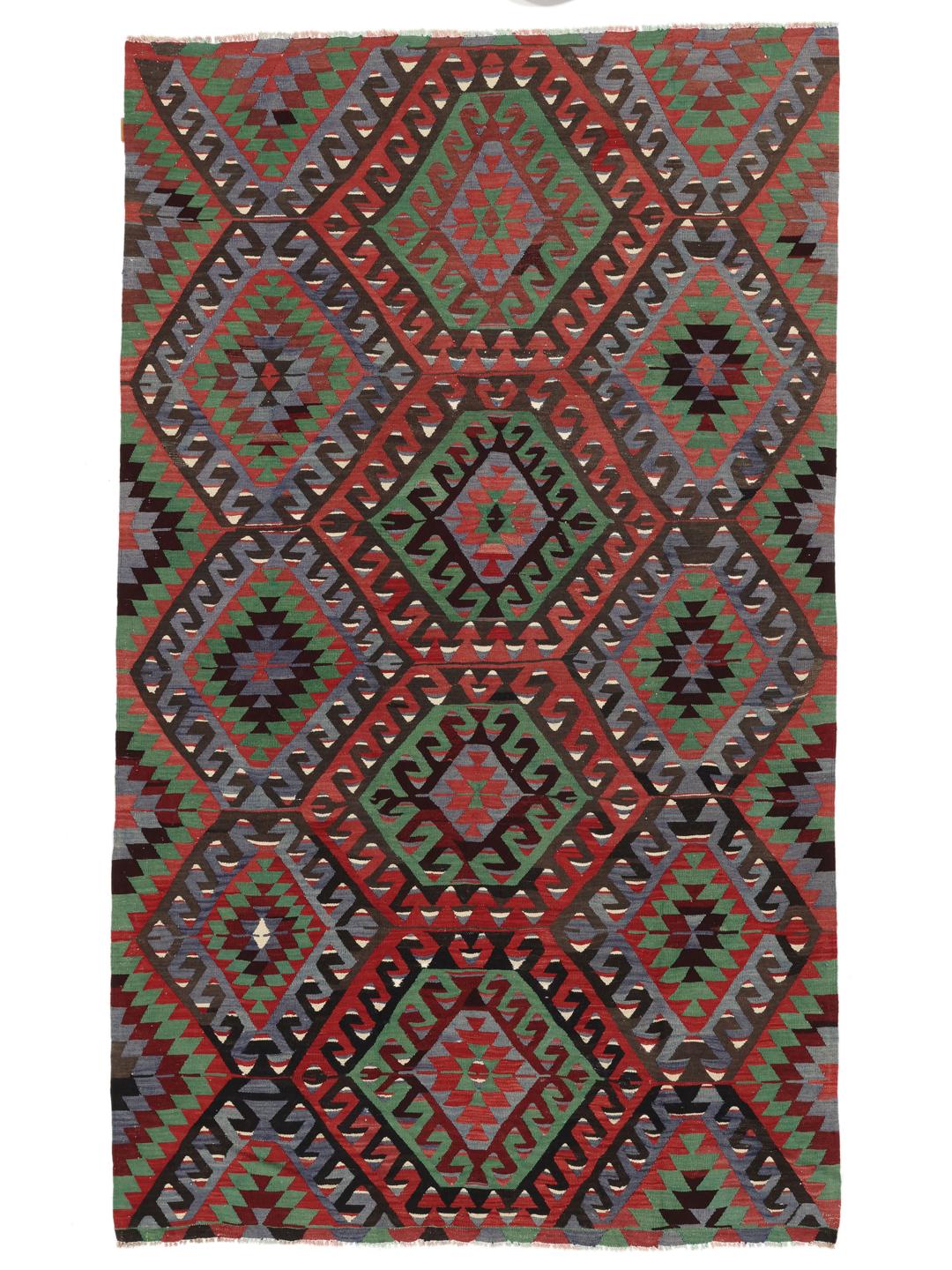Un tapis Kelim turc vintage présentant un motif géométrique vibrant dans des tons de rouge, vert et bleu.