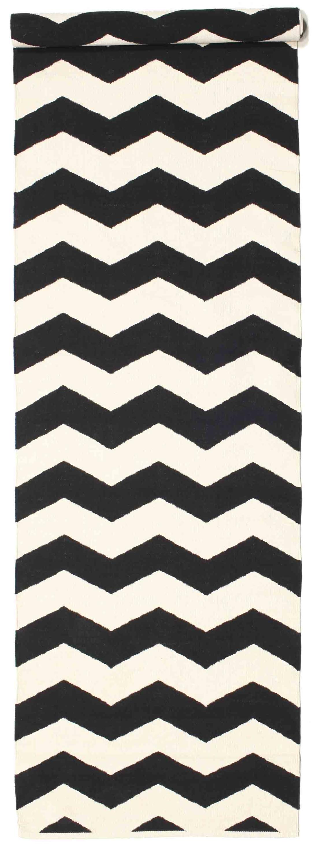 En sort og hvid løber med et gentagende zigzag-mønster.