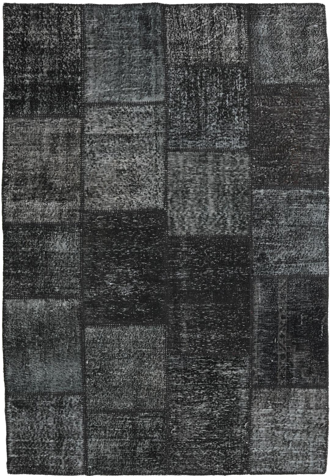 Een handgeknoopt Turks patchwork vloerkleed in diepzwarte tinten.