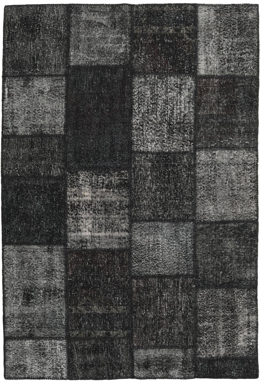 Een rechthoekig patchwork tapijt uit Turkije met een zwart-grijs ontwerp.