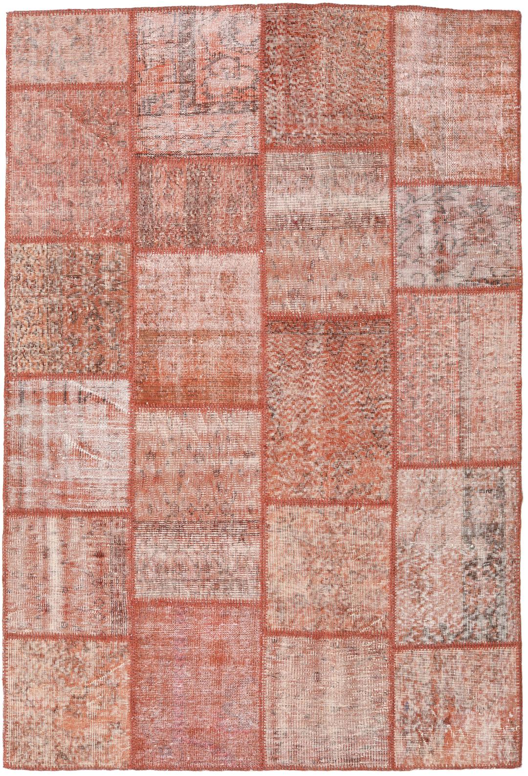 Een rechthoekig patchwork tapijt gemaakt van vintage Turkse wollen fragmenten in rode tinten.