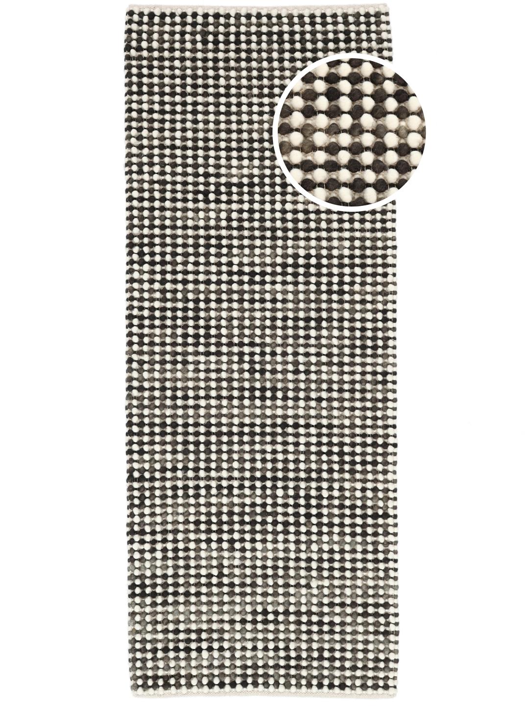 Un tapis de couloir tissé main gris foncé avec une finition en laine texturée.