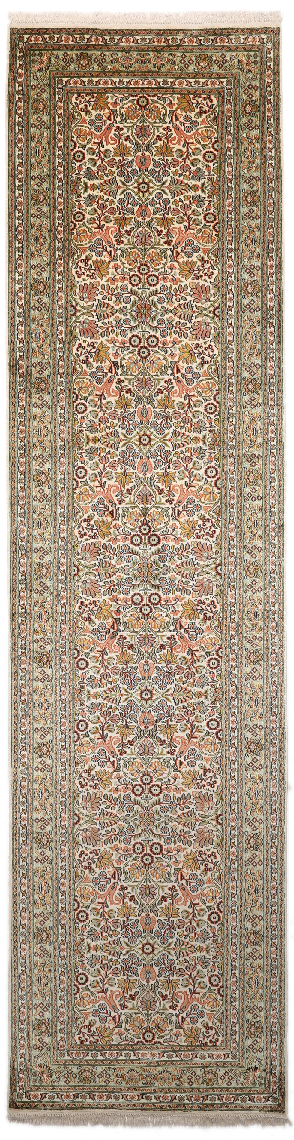 En lang, elegant Kashmir-silkelløber fra Indien med indviklede blomstermotiver i beige, grønne og bløde røde nuancer.