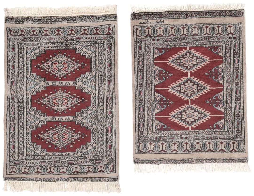 A rectangular hand-knotted Pakistan Bokhara rug with a deep red field and geometric motifs.