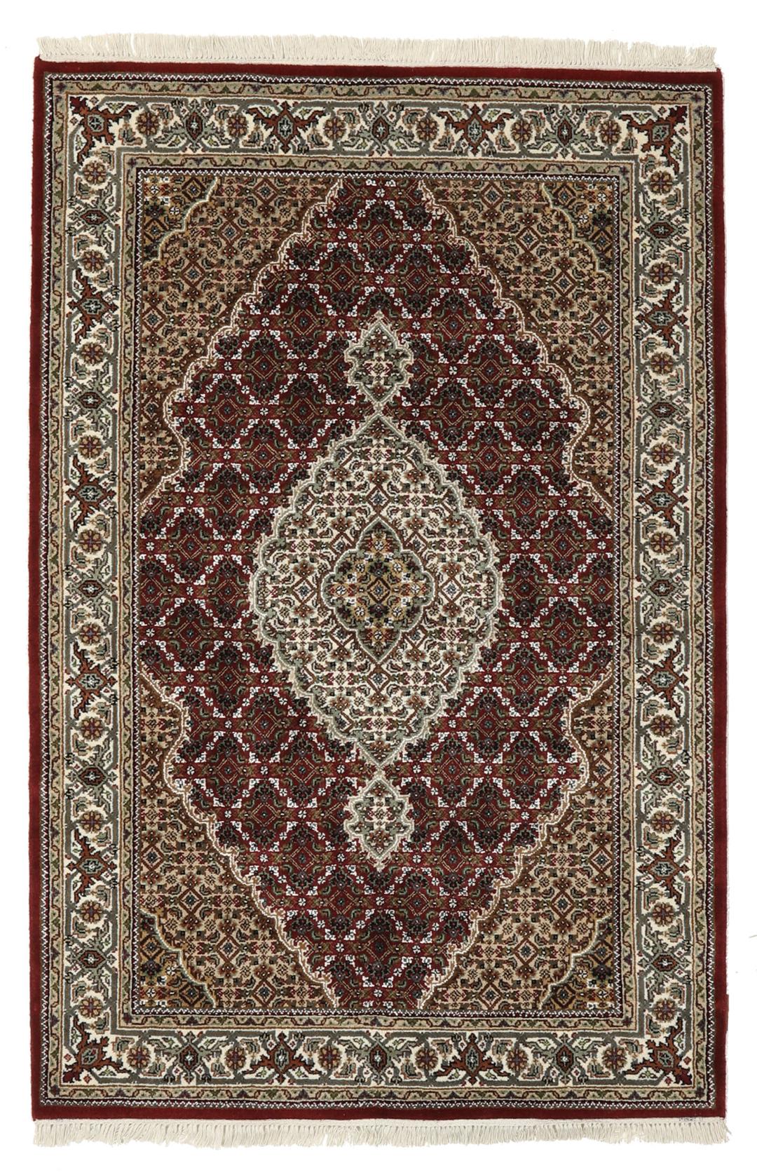 Een handgeknoopt Tabriz-tapijt uit India met een centraal medaillon in dieprood en crème.