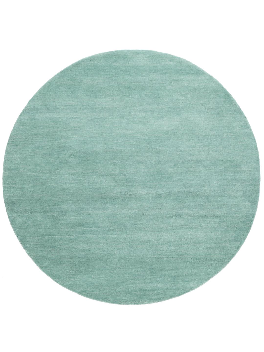 Round teal rug made from wool