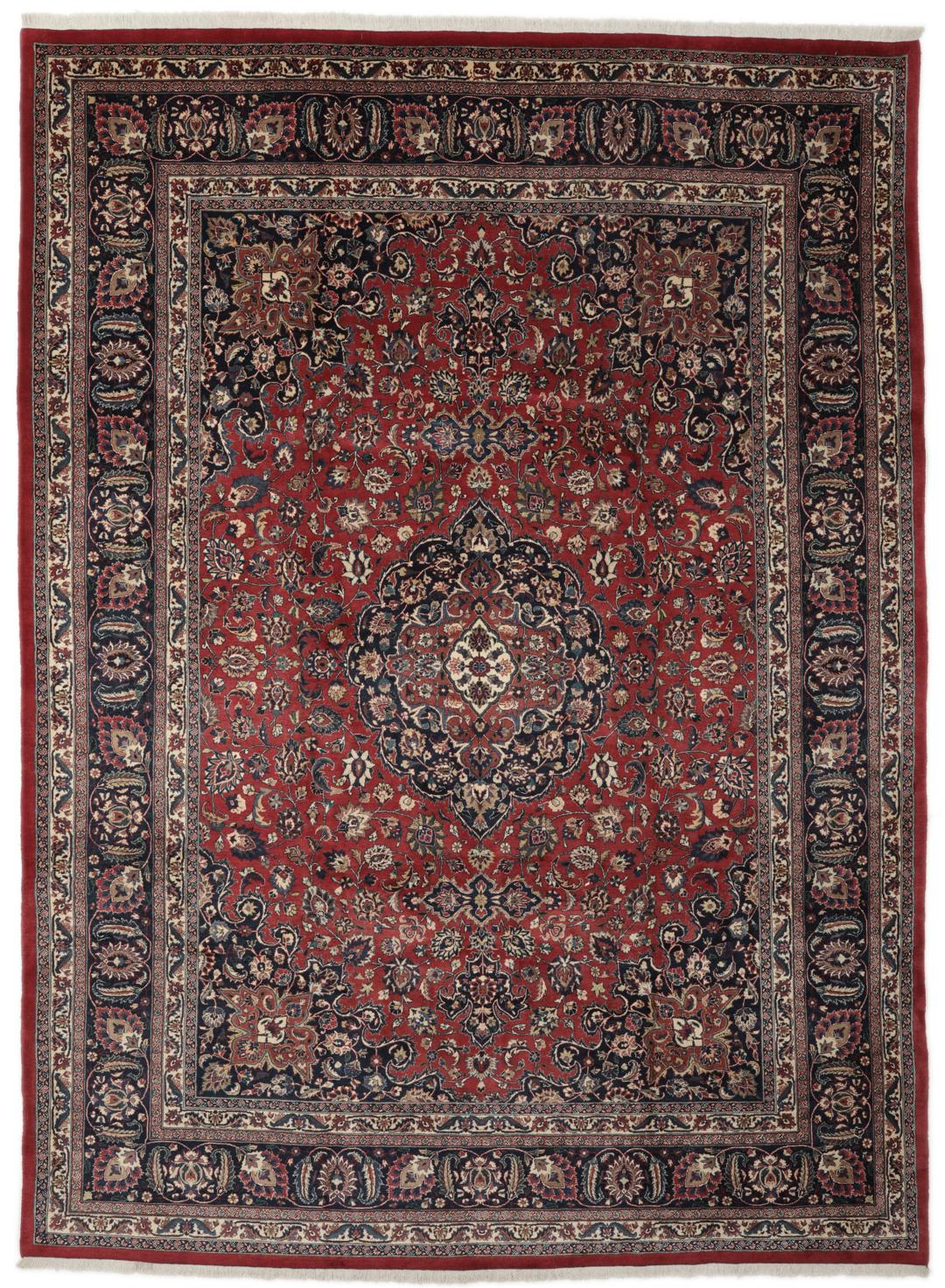 A large hand-knotted Mashad rug from the Middle East in deep red and blue tones