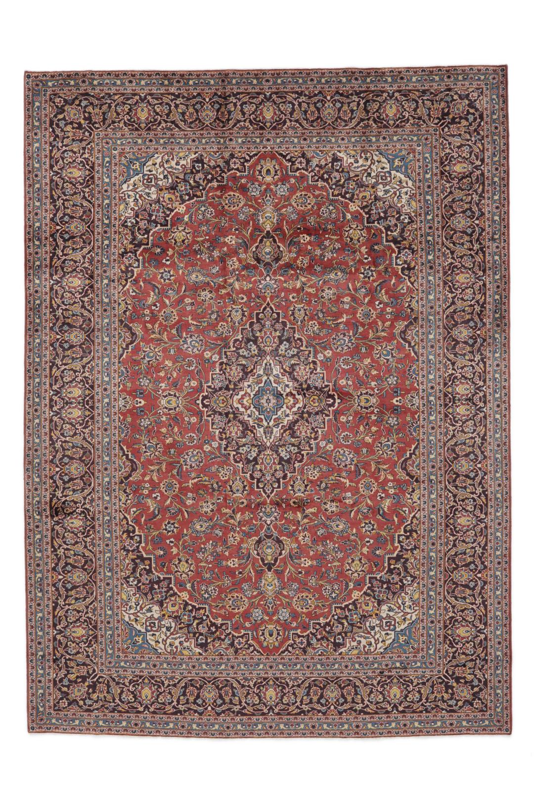 A large hand-knotted Keshan rug from the Middle East with a red floral pattern.