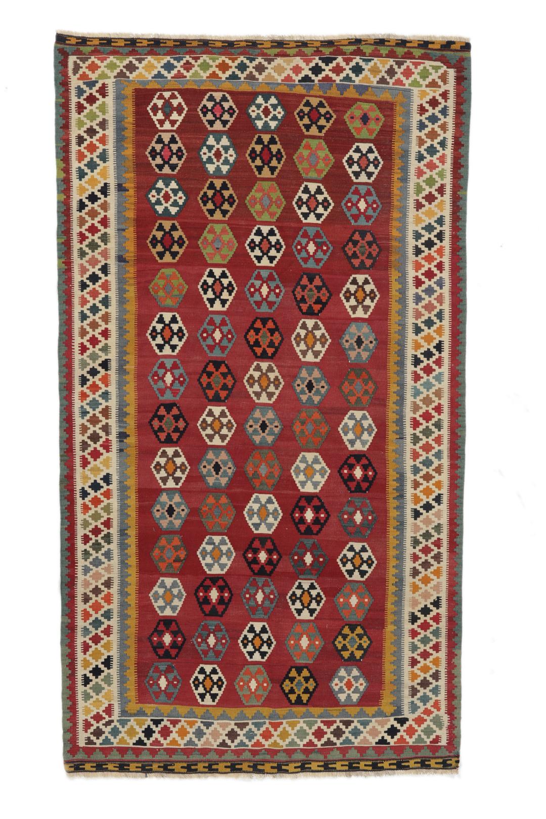 Een vintage handgeweven kelimkleed uit het Midden-Oosten met een rood veld en kleurrijke geometrische patronen.