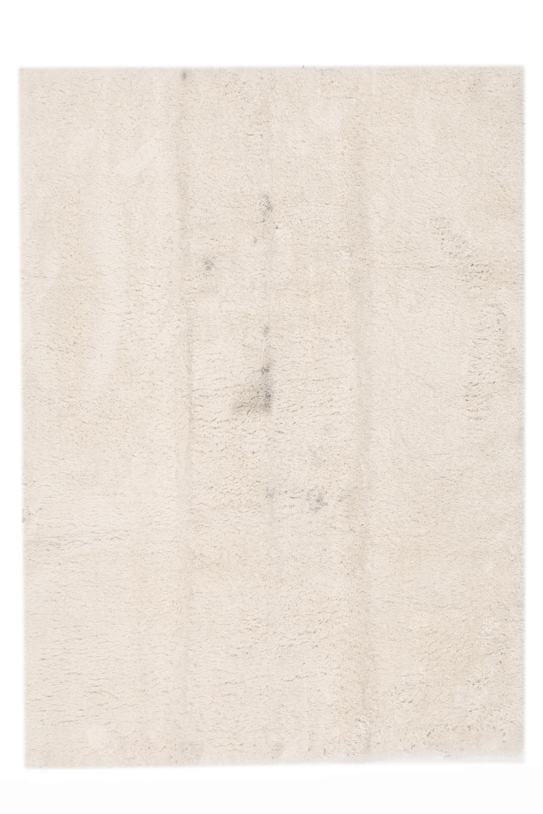 Um tapete bege claro felpudo com uma textura de pelo suave e profundo.
